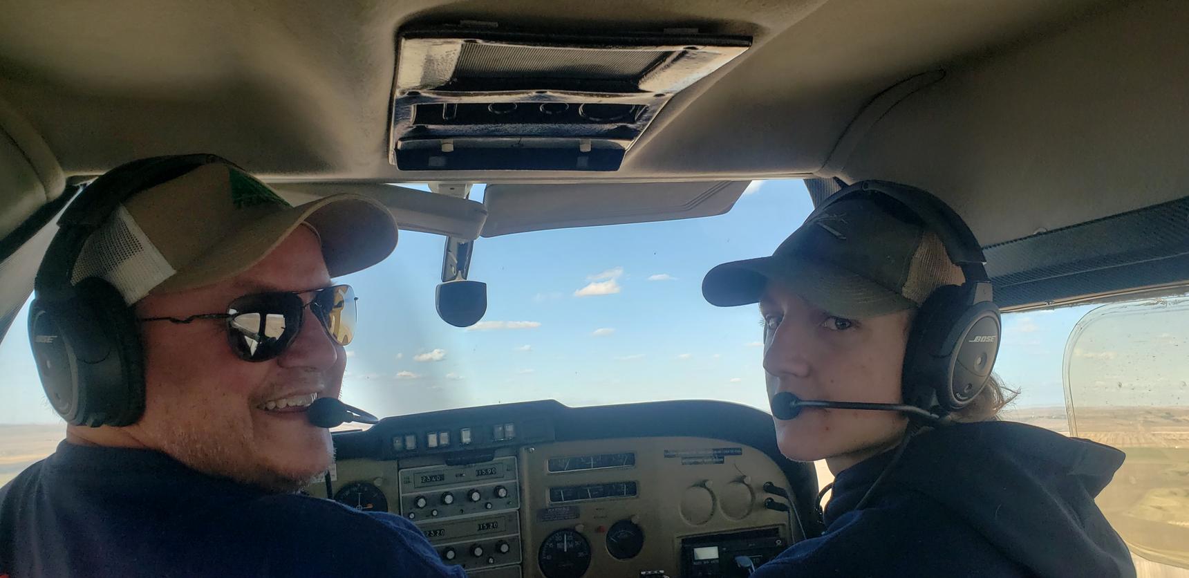 A image of 2 people inside the plane cockpit