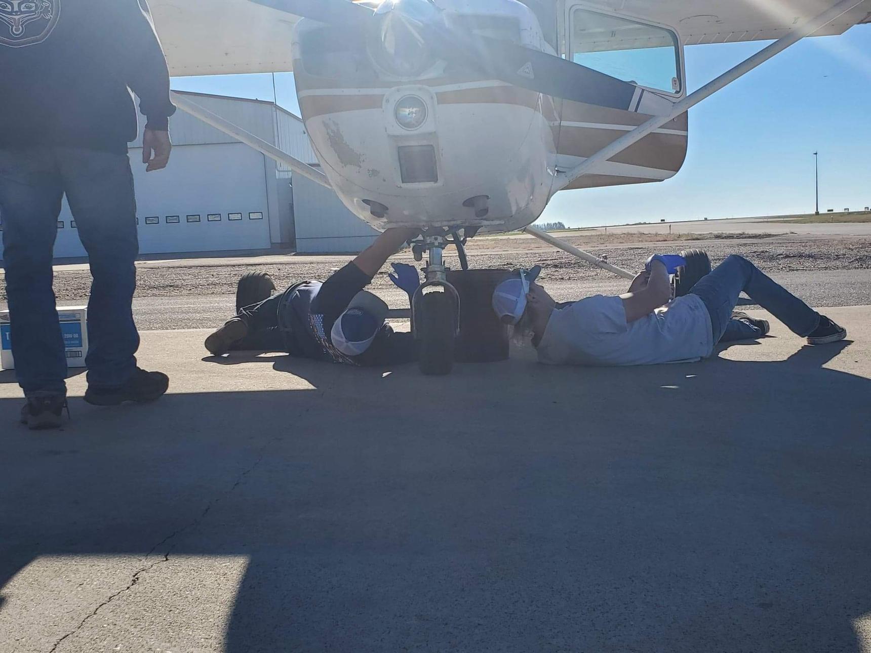 A image of people working on the plane outside