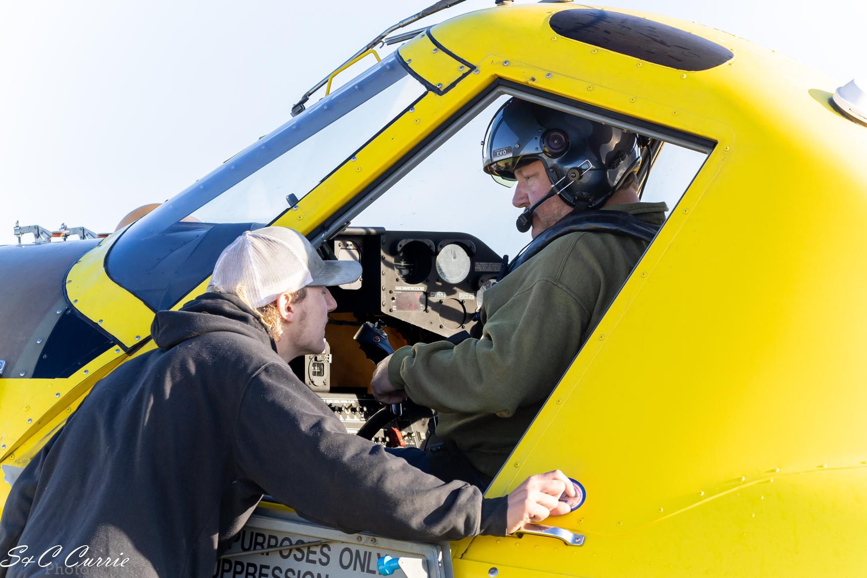 A image of a pilot talking to another person outside the plane